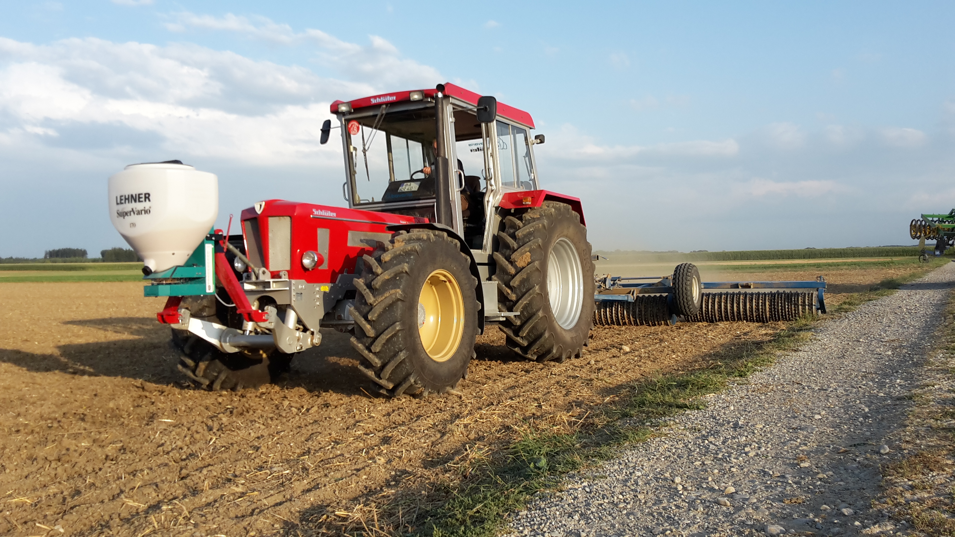 Schlüter Super 1250 VL mit Lehner Streuer und Rabe Walze